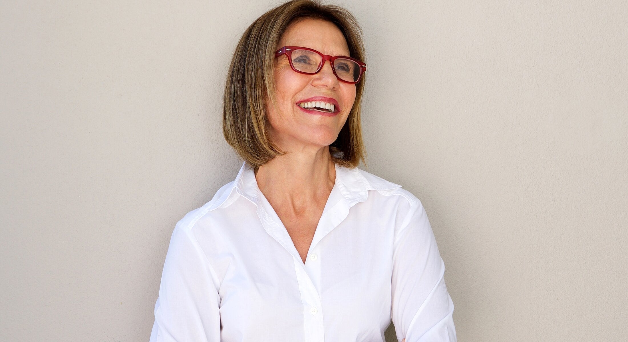 Woman holding silicone implants with red nails.